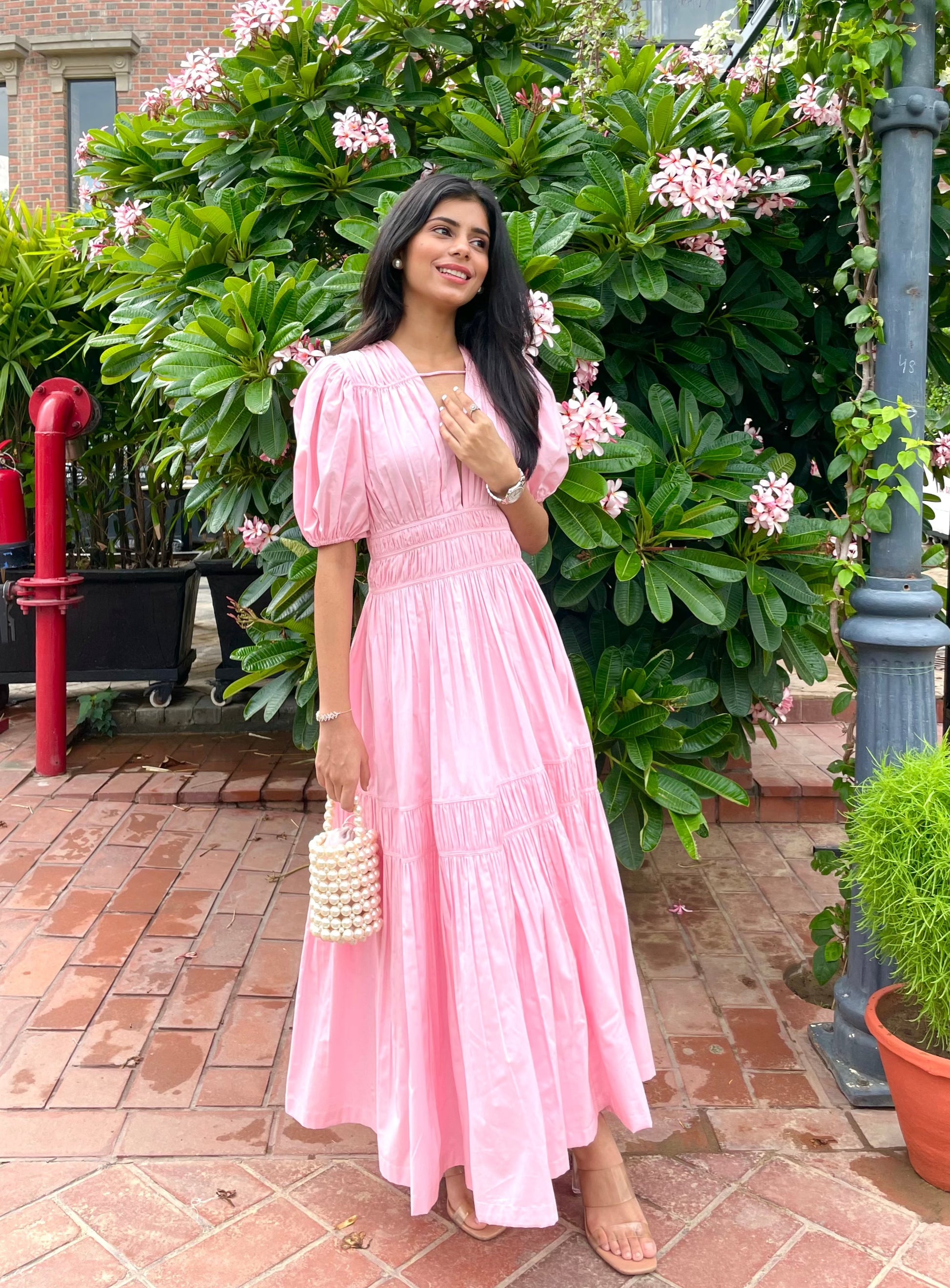 radhika merchant pink dress "Radhika Merchant radiates in a vibrant pink-orange gown, exuding a mix of contemporary elegance and festive charm. Her dazzling presence captivates everyone, showing how a perfect blend of fashion